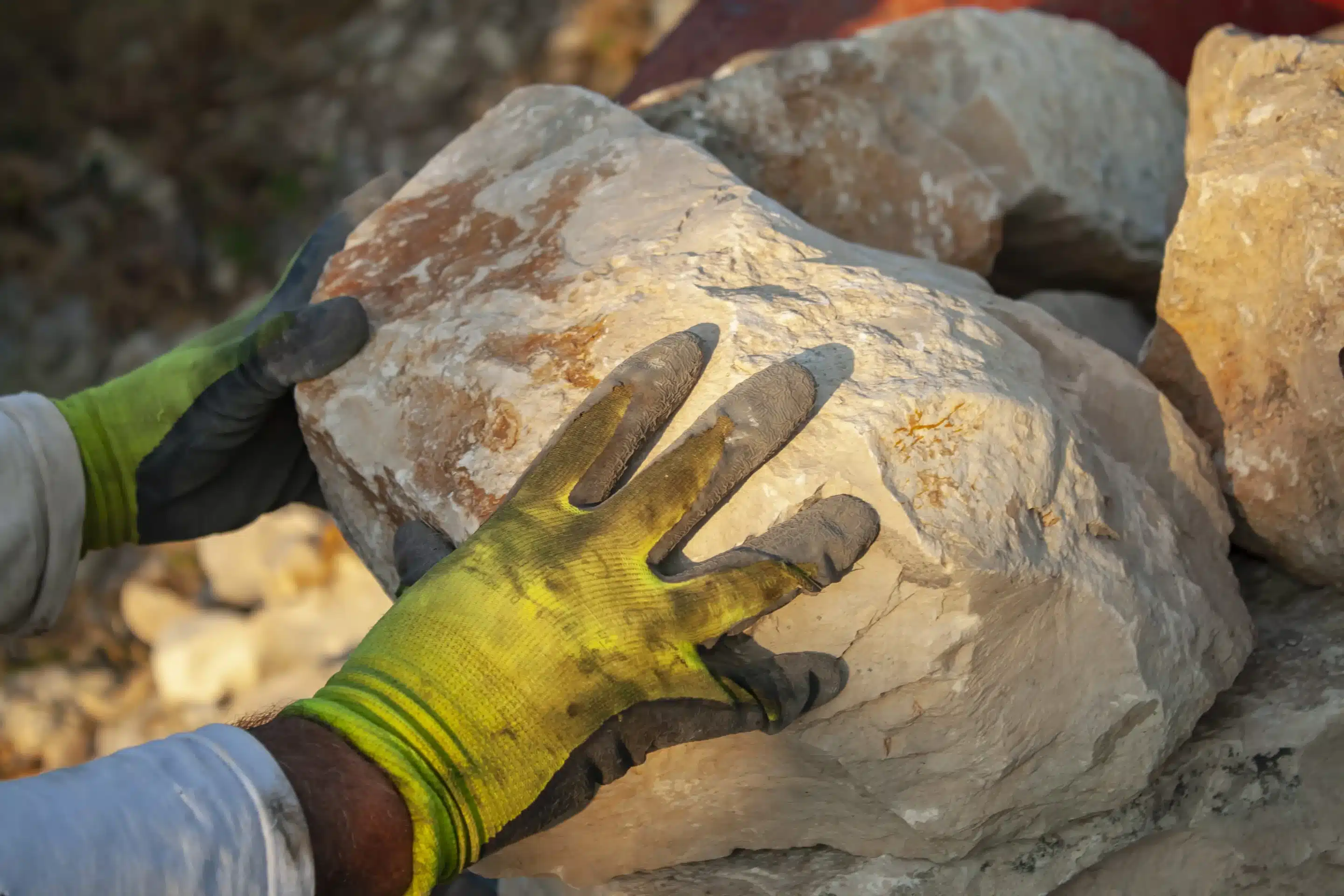 man's hand holding boulders supplier Texas